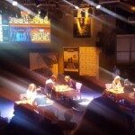 Vue plongeante sur la salle de jeu éclairée du tournoi CapEchecs, joueurs installés à leurs échiquiers.