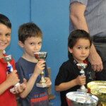 Trois jeunes joueurs brandissent leurs coupes lors de la dernière étape du Grand Prix Jeunes à Juvisy.