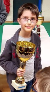 Un jeune joueur souriant brandit sa coupe lors de la 1re étape du Grand Prix Jeunes de l'Essonne.