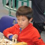 Un jeune joueur concentré devant son échiquier lors des championnats jeunes de l'Essonne.