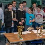 Équipe d'adolescents posant derrière une table de coupes au Championnat Écoles et Collèges 2019.