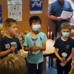 Trois jeunes joueurs masqués reçoivent leur coupe lors de la remise des prix du Grand Prix Jeunes de l'Essonne.