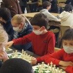 Jeunes joueurs masqués penchés sur leurs échiquiers pendant les championnats de l'Essonne 2021.