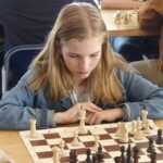 Jeune joueuse blonde concentrée sur sa partie lors du 20e Open rapide de Gif-sur-Yvette.