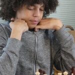 Une joueuse concentrée, appuyée sur ses mains, réfléchit devant son échiquier à l'Open rapide de Gif.