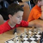 Un jeune joueur observe son échiquier lors de la compétition interdépartementale Loiret-Essonne.
