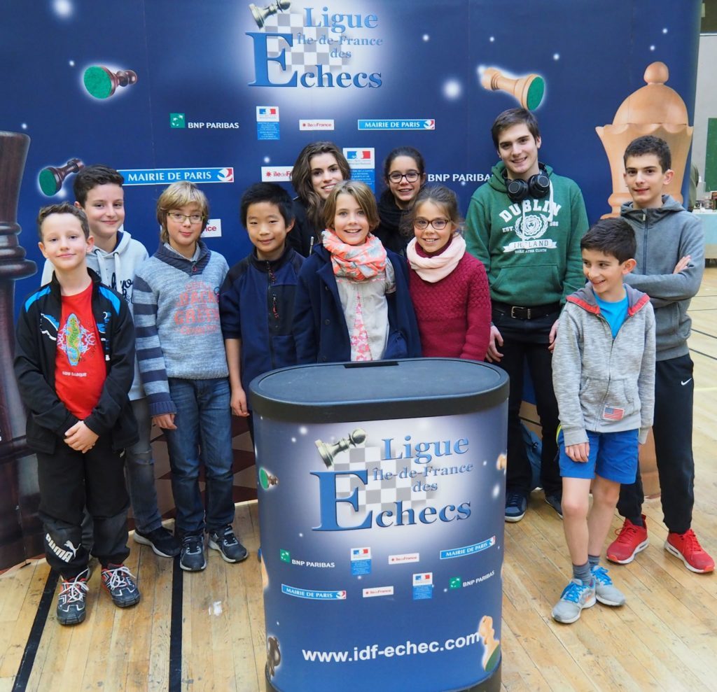 Groupe de jeunes Giffois posant devant le stand de la Ligue Île-de-France des Échecs.