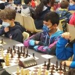 Deux jeunes joueurs masqués face à leurs échiquiers pendant les championnats de l'Essonne 2021.