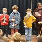Trois jeunes joueurs masqués reçoivent leurs coupes lors des Championnats d'Essonne 2021.