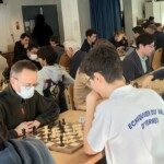 Rangée de joueurs concentrés sur leurs parties le long des tables du 22e Open de Gif-sur-Yvette.