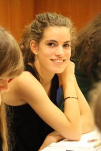 Une jeune joueuse souriante installée à sa table lors du Championnat d'Europe à Prague.