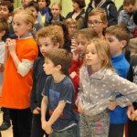 Des enfants debout écoutent l'annonce des résultats des championnats jeunes de l'Essonne.