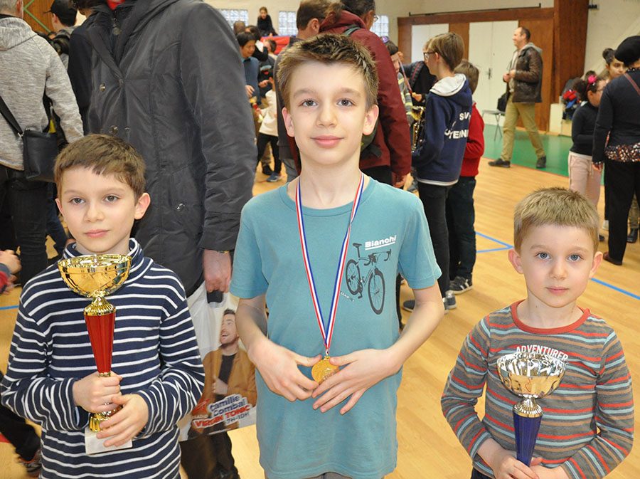 Trois jeunes joueurs présentent leurs coupes et leur médaille à la fin de l'étape de Nozay.