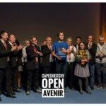 Groupe de joueurs sur scène devant l'écran de l'Open Avenir lors du tournoi CapEchecs.