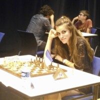 Une joueuse installée à son échiquier, main sur la tempe, lors du tournoi d'Avoine.