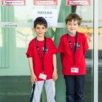Deux jeunes joueurs en tenue rouge du club, badges au cou, au Championnat de France jeunes de Montbéliard.