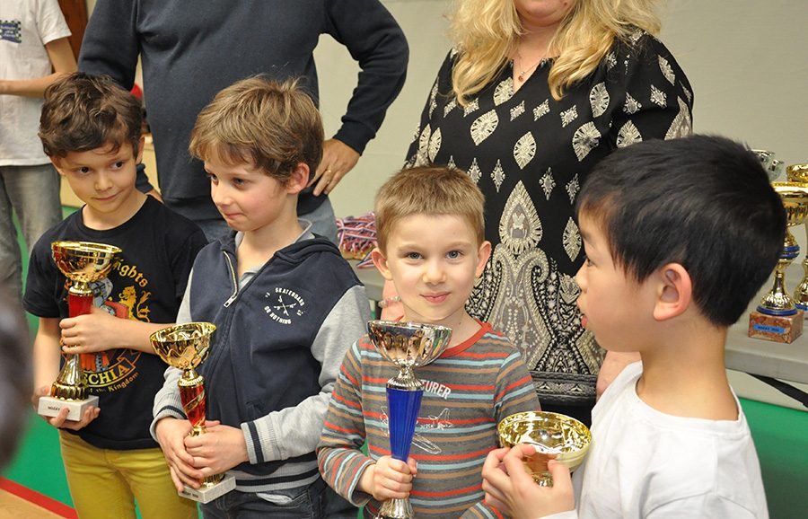 Quatre jeunes joueurs serrant leurs coupes lors de la remise des prix de l'étape de Nozay.