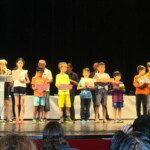 Rangée de jeunes joueurs alignés sur la scène lors de la remise des prix de l'Open de Dieppe.