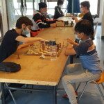Enfants masqués disputant leurs parties autour d'une table lors du Grand Prix Jeunes de l'Essonne.