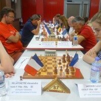 Joueurs alignés en salle de tournoi, drapeaux et pancartes de table, lors du festival d'Avoine.