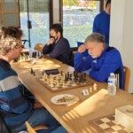 Adultes concentrés sur leurs parties le long d'une grande table au 22e Open de Gif.