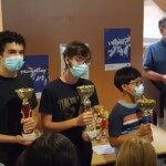 Trois jeunes joueurs masqués brandissent leurs coupes à l'étape du Grand Prix Jeunes de l'Essonne.