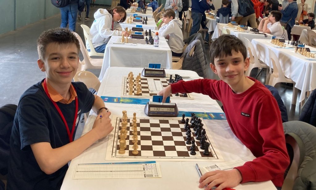 Deux jeunes joueurs souriants à leur table lors des Championnats de France Jeunes d'avril 2022.